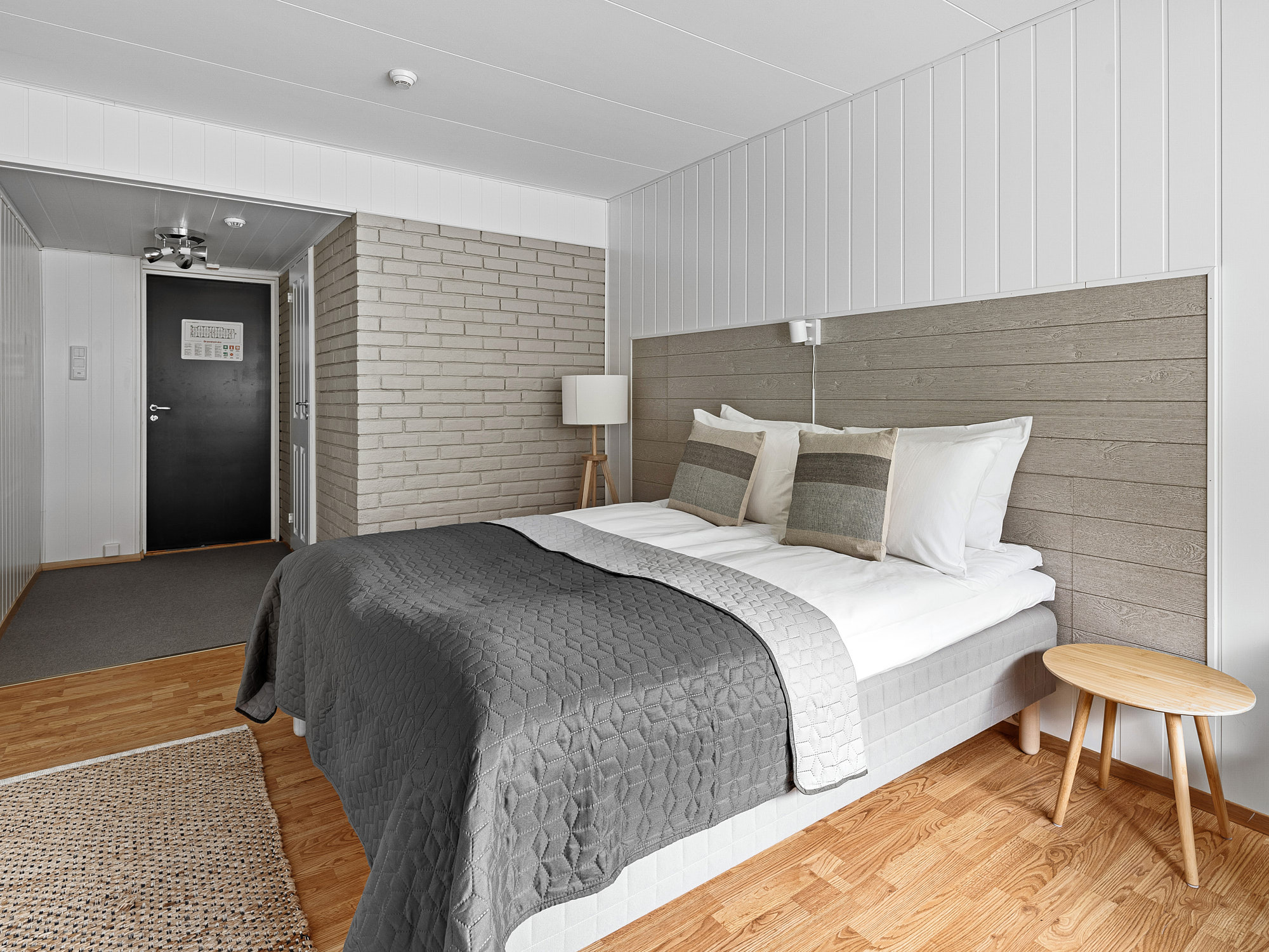 Komfortabelt dobbeltrom på Eidfjord Hotel med store vinduer og panoramautsikt over fjell og natur.