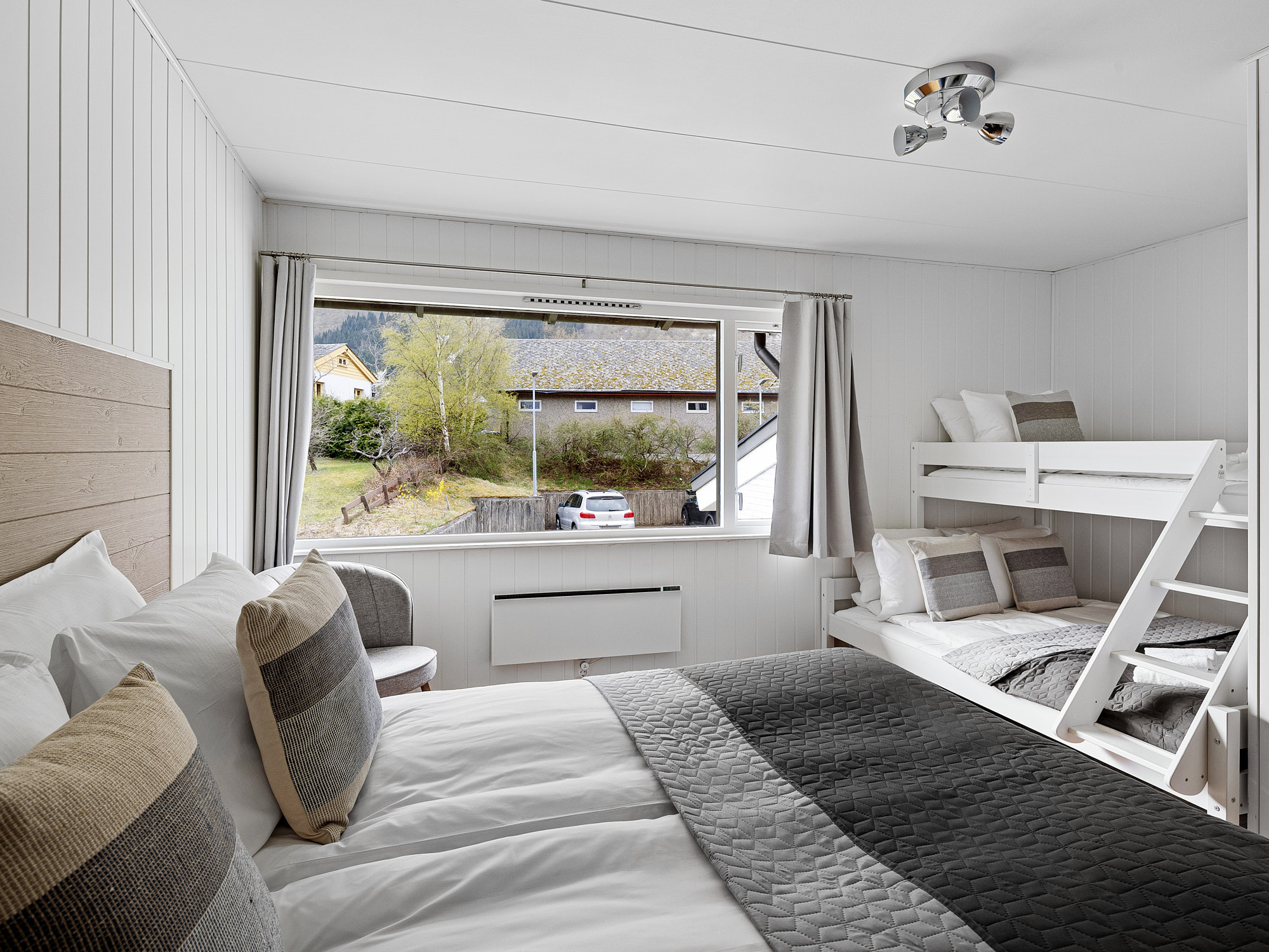 Romslig familierom på Eidfjord Hotel med dobbeltseng og køyeseng, perfekt for familier som ønsker komfort og nærhet til fjord og fjell.