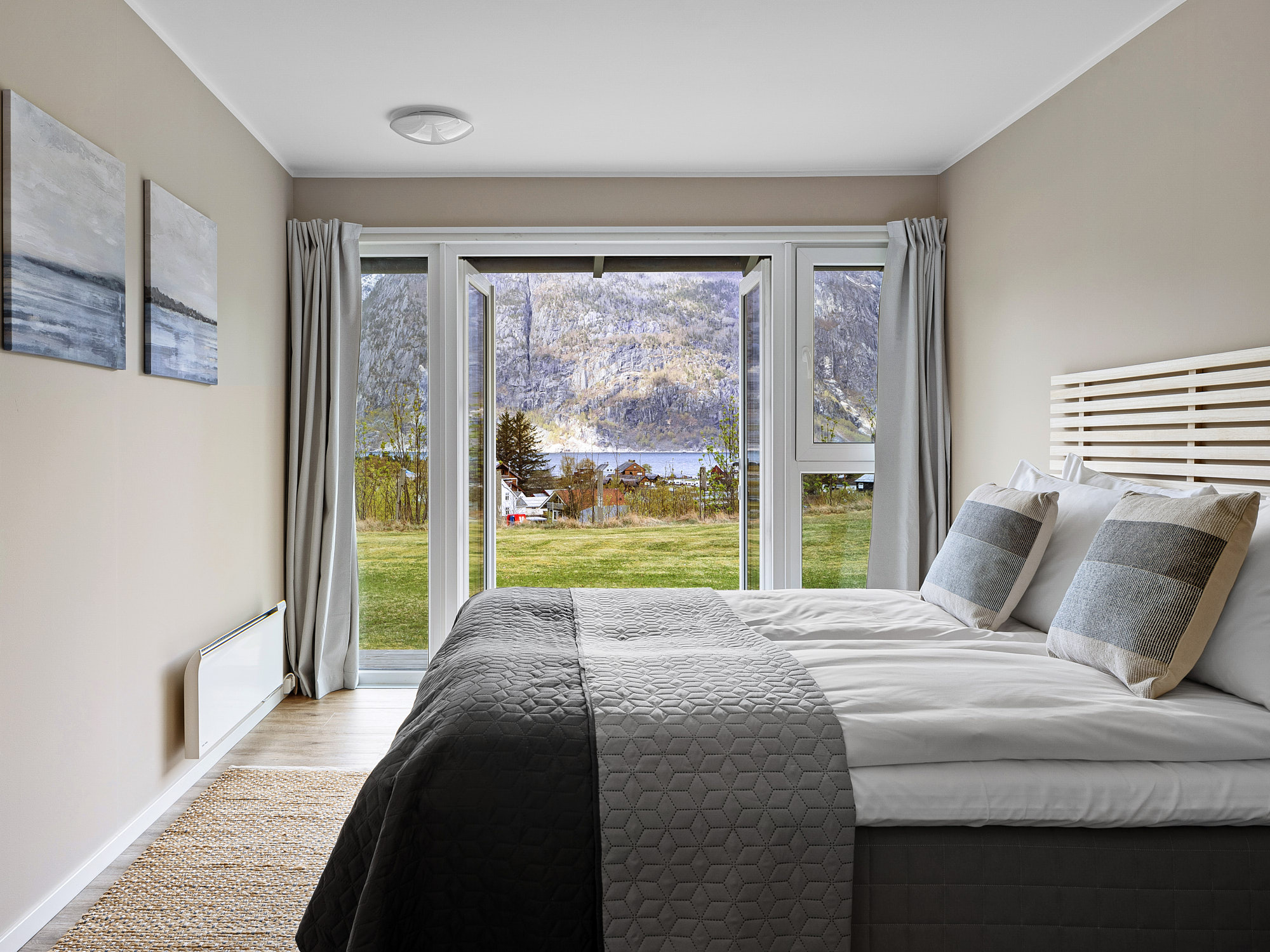 Quarto do Eidfjord Hotel com parede de vidro e vista para o fiorde